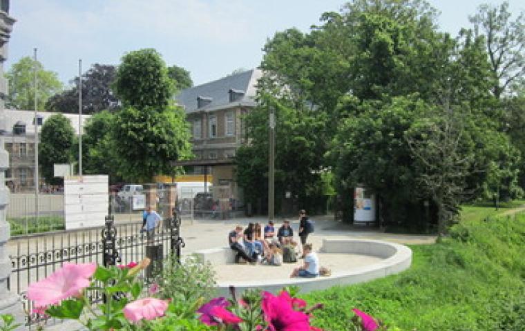 Jongeren zitten op het zitelement aan de Kruidtuin.